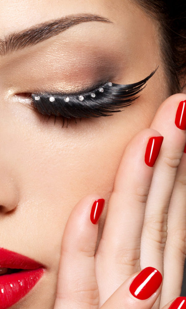 fashion woman with modern creative makeup using false eyelashes red manicure scaled e1653061384955